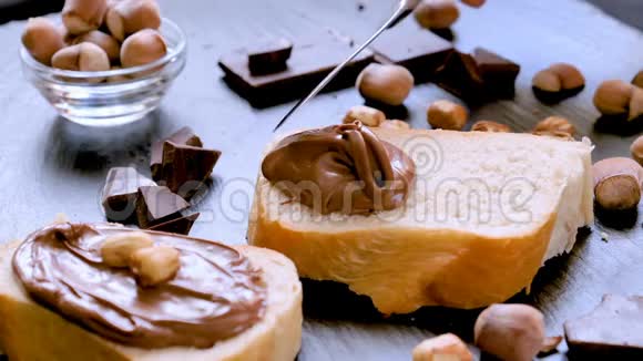 将榛子巧克力奶油涂在面包特写上视频的预览图