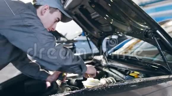 在车库工作的穿工作服的机械师修理豪华跑车视频的预览图