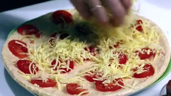 一个女人用切碎的奶酪洒比萨饼基地视频的预览图