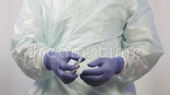 戴医用手套的男医生的手将药片从包装中取出必须将药片送到病人手中视频的预览图