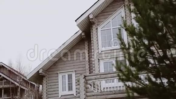 一栋两层楼的房子的屋顶和附近的一棵树的景色视频的预览图