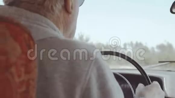 在非城市道路上老人乘坐复古车的后视角视频的预览图
