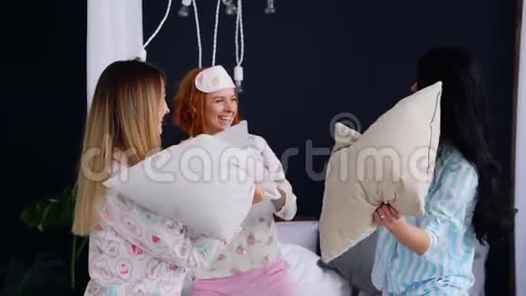 为了庆祝婚礼三个年轻的女人在一个睡衣派对上打枕头视频的预览图