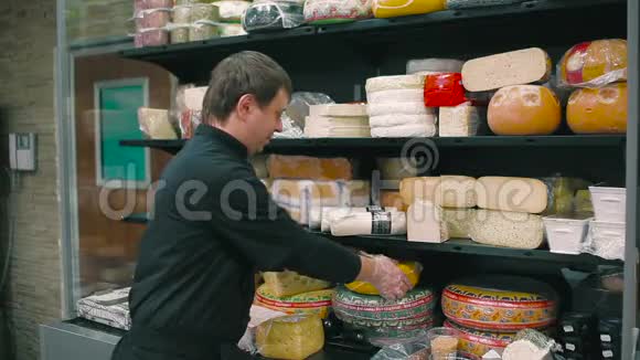 微笑推销员在摄像机上演示奶酪视频的预览图