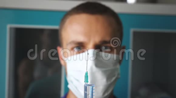 年轻的白种人医生戴着面具从注射器里倒出液体的肖像医务人员准备注射器视频的预览图