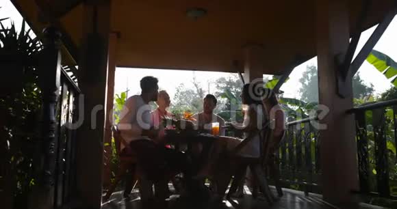 人们聚集在露台上吃早餐朋友在早上用餐时交流视频的预览图