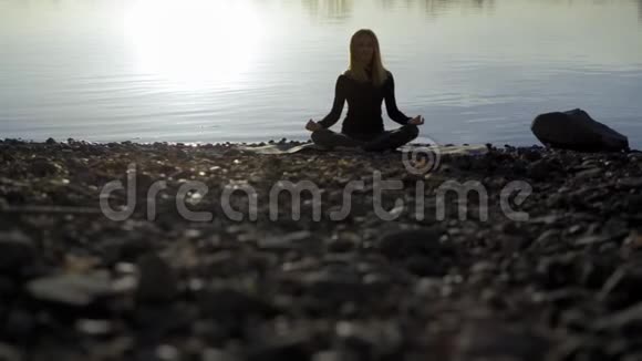 瑜伽女人呆在河岸上冥想视频的预览图