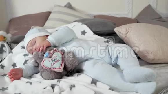 小男孩抱着玩具睡着了孩子睡在父母的床上睡在枕头间舒适气氛中视频的预览图