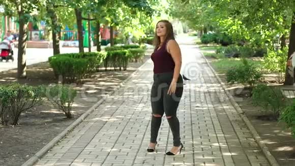 一个体重超标的年轻快乐女孩在一个夏季公园散步加上尺寸模型视频的预览图