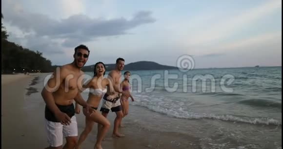 在海上奔跑的快乐人群在沙滩上快乐地混合着种族朋友视频的预览图
