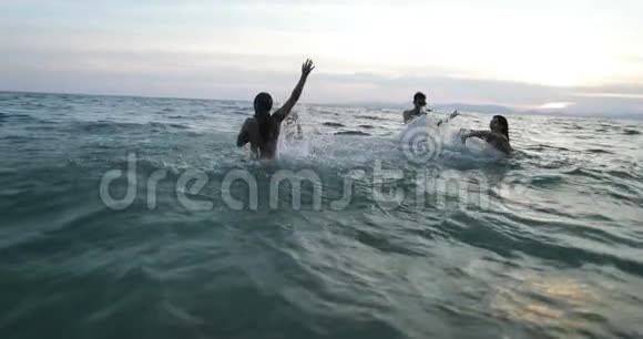 一群快乐的朋友在夕阳下的海上游泳年轻人在沙滩上尽情嬉戏视频的预览图