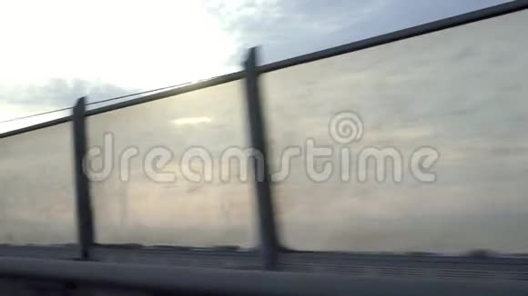 从移动机器或火车的窗户上拍摄肮脏的透明栅栏的视频摄像机沿着闪烁的太阳移动视频的预览图