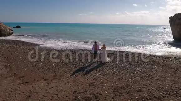 一对漂亮的夫妇走在海边视频的预览图