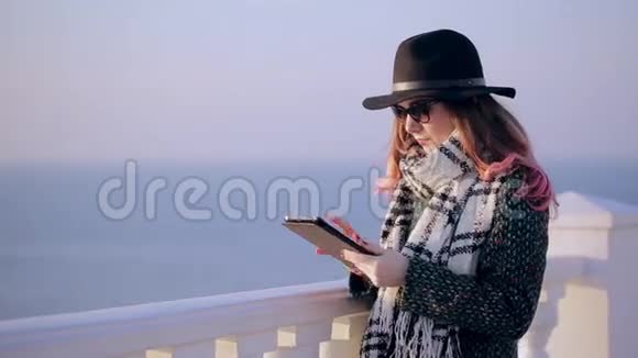 美丽的黑发使用数字平板触摸屏海普斯特海滩上有平板电脑的女孩视频的预览图