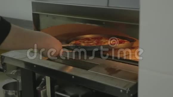 厨师从烤箱里拿出煮好的披萨视频的预览图