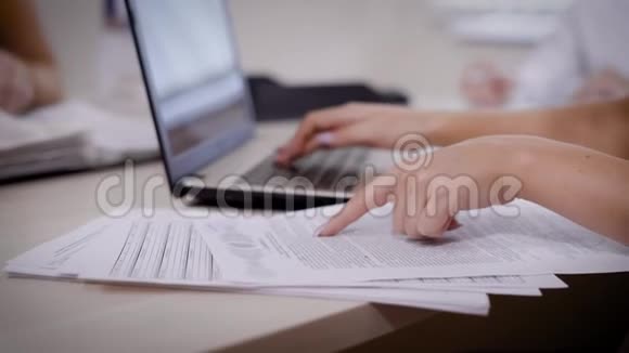 在笔记本电脑上打字仔细阅读重要的纸张视频的预览图