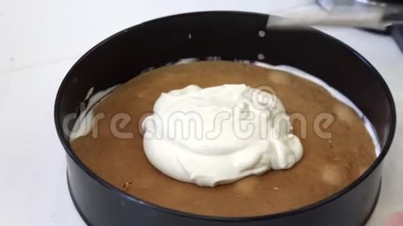 手把白色奶油放在圆饼上视频的预览图