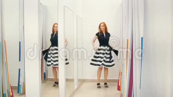 穿着试衣间镜子的红发女孩购物理念视频的预览图