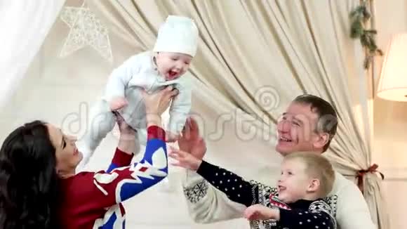 幸福的家庭爸爸妈妈和孩子们在房子里快乐地玩耍小宝宝手捧着父母开心地笑着视频的预览图