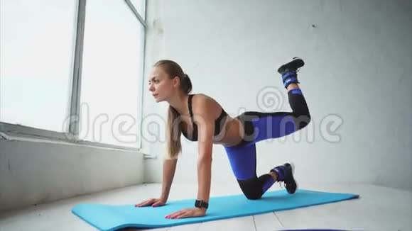 年轻而运动的女孩用腿做活动腿来加强臀部视频的预览图