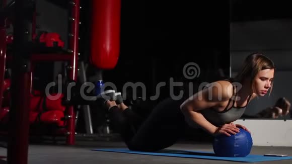 一个深黑肤色的运动员在健身房的大砍刀上做俯卧撑把秒表放在手机上拳击训练视频的预览图