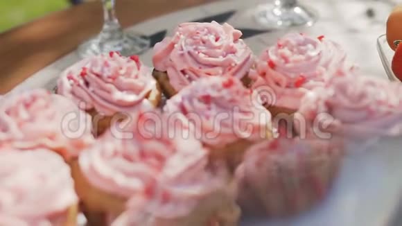 在桌上的甜点盘上用粉红色的美味奶油夹在篮子里为您提供贴心的甜点视频的预览图