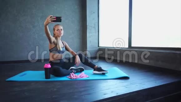 健身后美女在智能手机上自拍视频的预览图