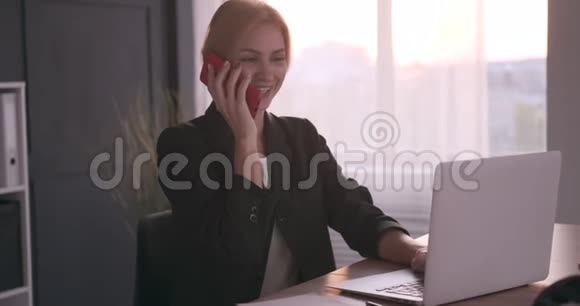 在办公室使用手机和笔记本电脑的女商人视频的预览图