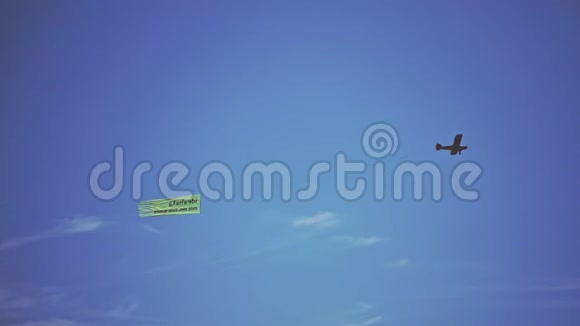 单发机飞机在空中飞行小型飞机拖挂广告横幅视频的预览图