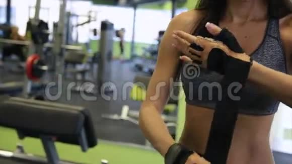 漂亮的模特女士戴着手套在健身室健身房准备训练力量适合身体视频的预览图