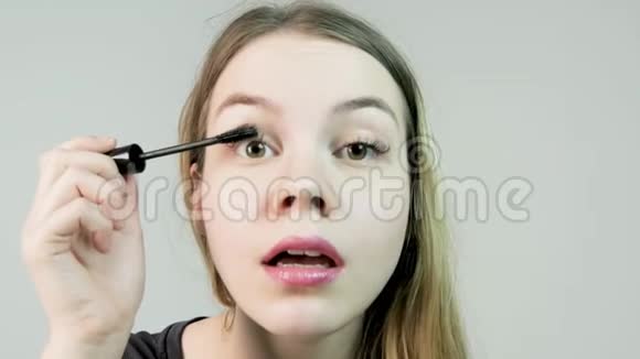 女人的眼睛有美丽的妆容和长长的睫毛马斯卡拉刷一张漂亮年轻女士的摄影棚时装照片视频的预览图