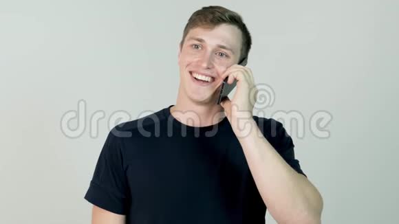 一个微笑的拉丁成年男子在白底手机上讲话的肖像打电话的年轻人视频的预览图