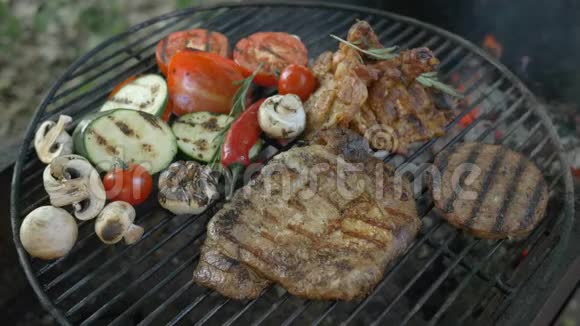 肉和蔬菜放在烤架上背景是火和烟一道菜肉放在骨头上白肉视频的预览图