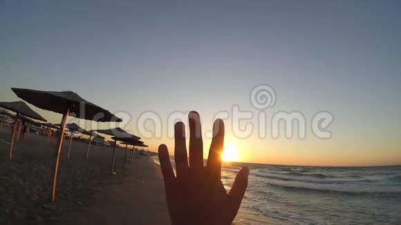 手指头夕阳夕阳海滩大海视频的预览图