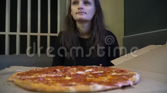 可爱的女人坐在咖啡馆里享受披萨视频的预览图