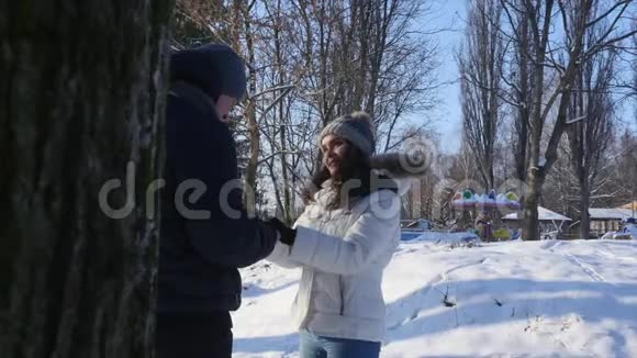 在冬天的公园里年轻夫妇微笑着互相交谈视频的预览图