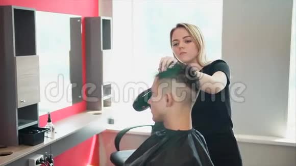 女理发师整理发型她给顾客烘干吹风机视频的预览图