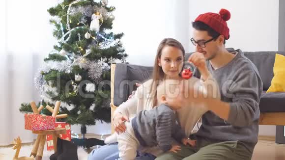 年轻快乐的家庭母亲父亲和小男孩穿着毛衣在圣诞节和新年附近玩得很开心视频的预览图