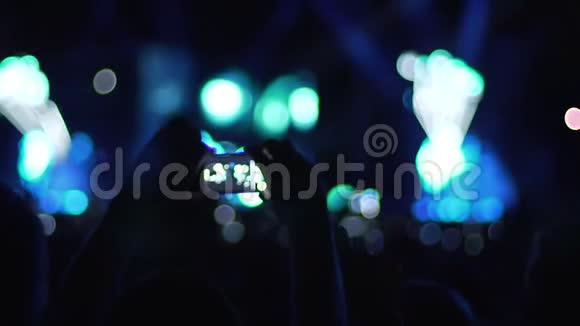 在音乐厅拍摄流行歌手表演视频的人观众的影子视频的预览图