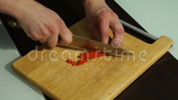 切片红辣椒一个男人在木板上切胡椒视频的预览图