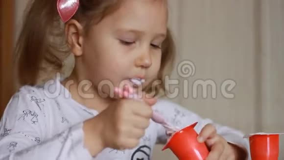 小女孩用勺子吃奶酪宝宝吃乳制品酸奶肖像特写视频的预览图