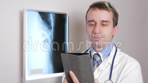 一位年轻的医生在诊所里使用平板电脑一名男子记录了一名病人x线的结果视频的预览图