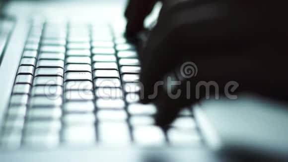 男人手在键盘上对着灯光打字的剪影视频的预览图
