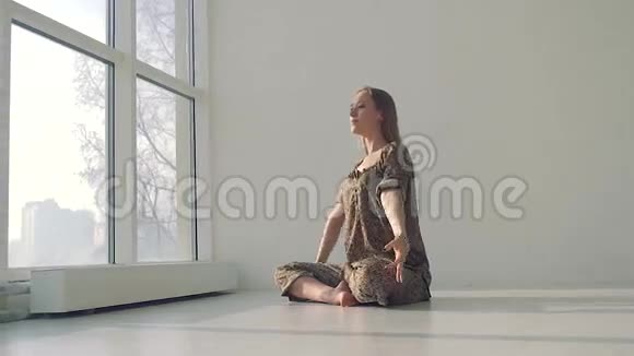 年轻冷静的女人在光线充足的工作室做瑜伽视频的预览图