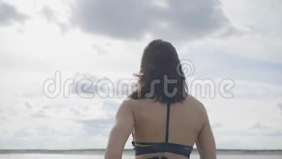强壮的黑发正在海滩上训练视频的预览图