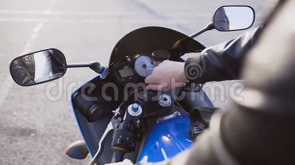 摩托车手插入钥匙启动点火循环发动机的发动机视频的预览图