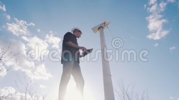 风车发电厂工程师手持平板电脑天空背景视频的预览图