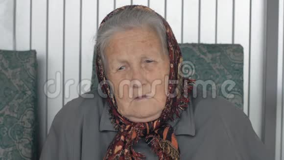 一位身穿棕色头巾的老妇人的特写肖像视频的预览图