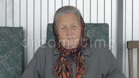 一位身穿棕色头巾微笑的老妇人的肖像视频的预览图
