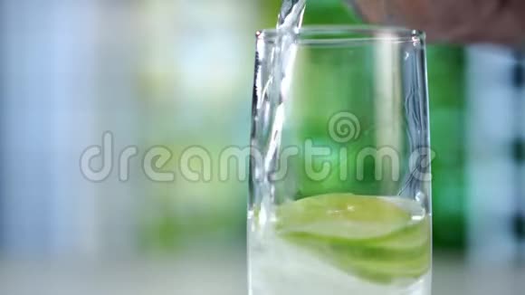 将一杯清爽的饮料倒入冰块柠檬和石灰中视频的预览图